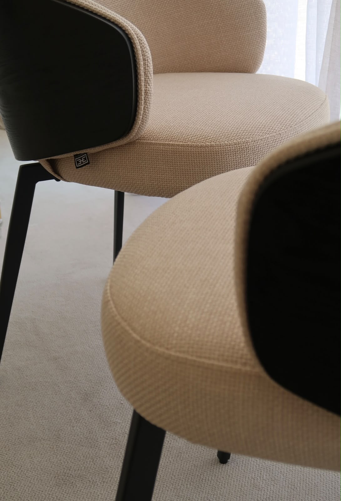 Close detail of piped seam between woven fabric and black leather